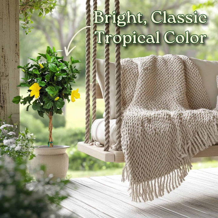 Swinging chair with a beige blanket on a wooden deck, surrounded by greenery. #trunk_braided
